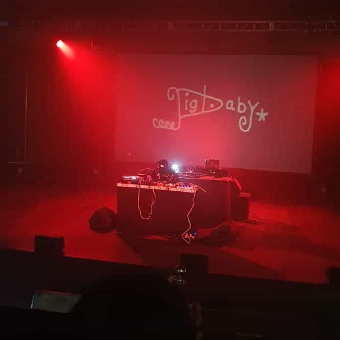 pigbaby live set, the backdrop visual saying 'pigbaby' in stylized doodled text