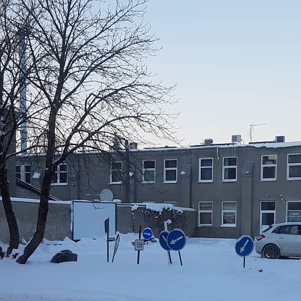 small snowy parking lot with several traffic reroute arrow and other signs dappling it