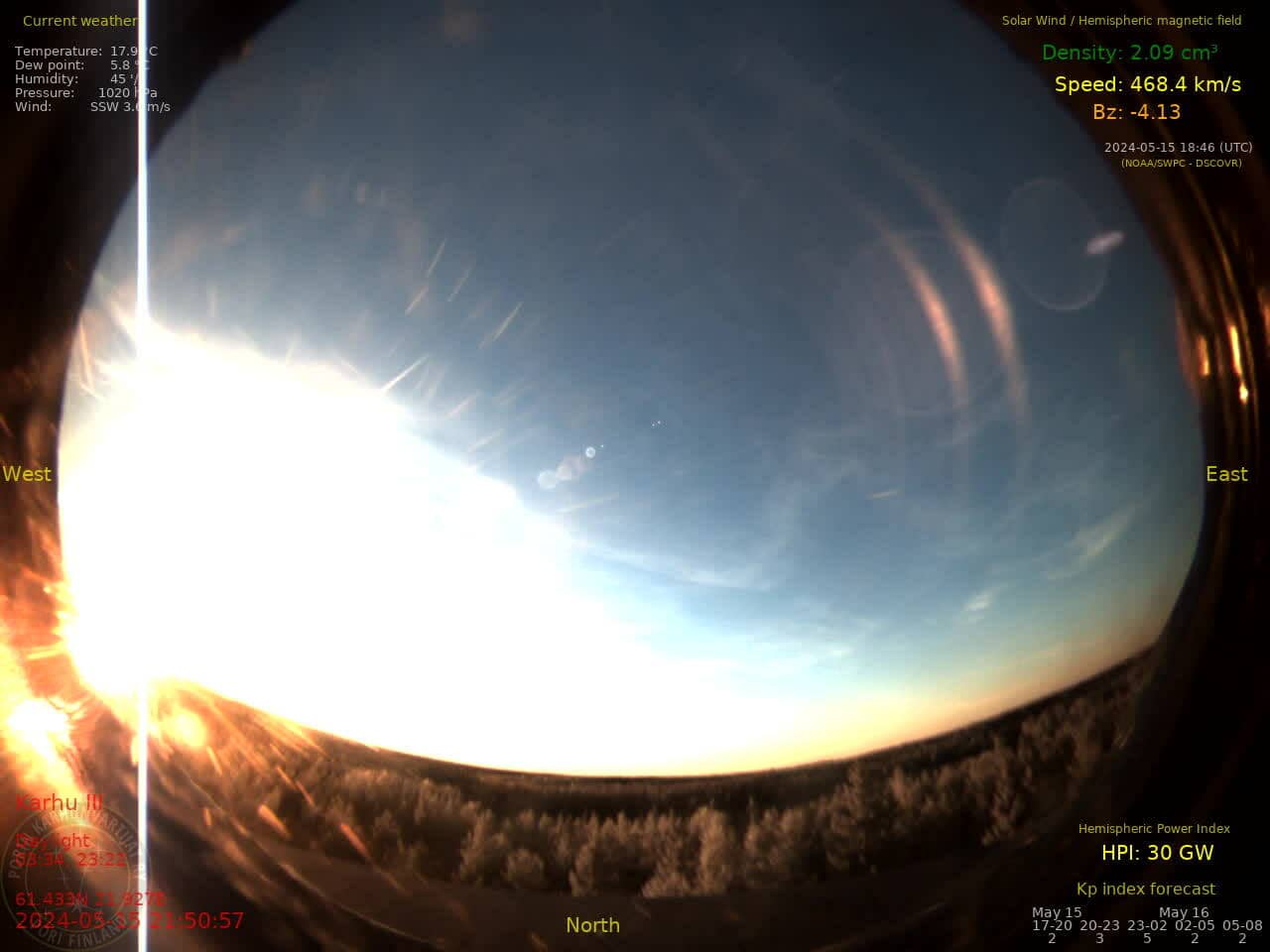 fisheye-lens northward view of an overexposed sunset, the sun at the very left, with significant lens flaring, from midmay 2024 nearly 10pm